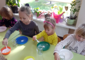 Dzieci nabierają na łyżeczkę sól potrzebną do eksperymentu